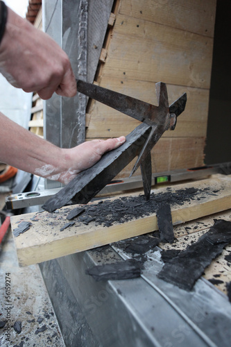 Photo: Roofer smashing slate tiles Roofer smashing slate tiles