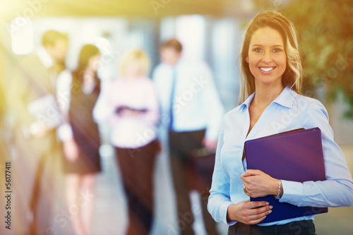 Photo: Bussinesswoman over team background Bussinesswoman over team background