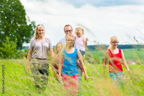 Photo: Happy Family walking in the meadow Happy Family walking in the meadow