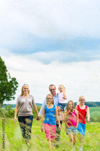 Photo: Happy Family walking in the meadow Happy Family walking in the meadow