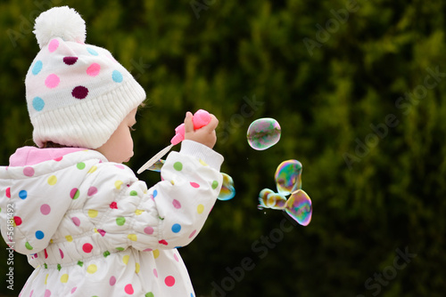 Photo: toddler girl blowing soap bubbles toddler girl blowing soap bubbles