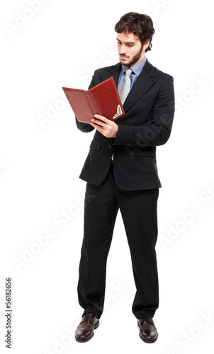 Photo: Full length businessman reading his agenda Full length businessman reading his agenda