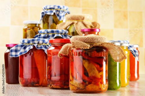Photo: Composition with jars of pickled vegetables. Marinated food Composition with jars of pickled vegetables. Marinated food