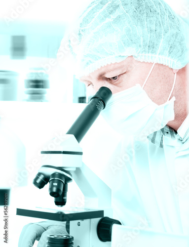 Photo: Scientist looks into microscope Scientist looks into microscope