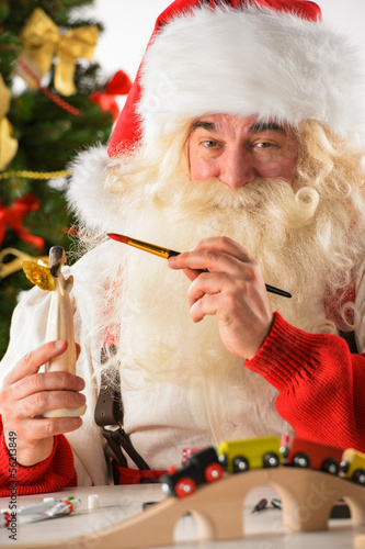 Photo: Santa Claus in his workshop making new toys Santa Claus in his workshop making new toys