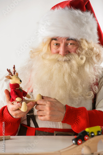 Photo: Santa Claus in his workshop making new toys Santa Claus in his workshop making new toys