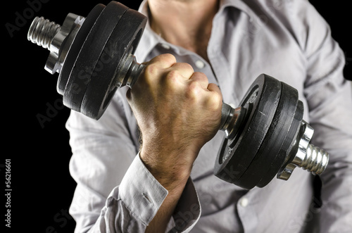 Photo: Closeup of businessman lifting weights Closeup of businessman lifting weights