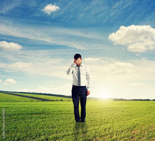 Photo: unsuccessful man standing on the field unsuccessful man standing on the field