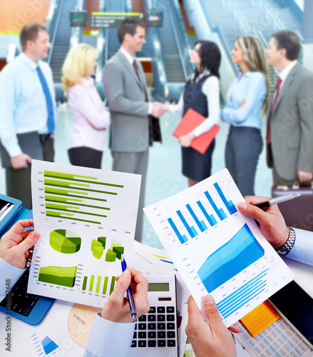 Photo: Business people working with graphs. Business people working with graphs.