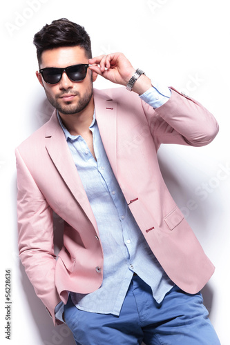 Photo: casual man fixing his sunglasses with a hand in pocket casual man fixing his sunglasses with a hand in pocket