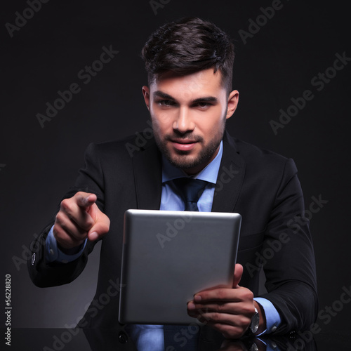 Photo: young business man with tablet points at camera young business man with tablet points at camera