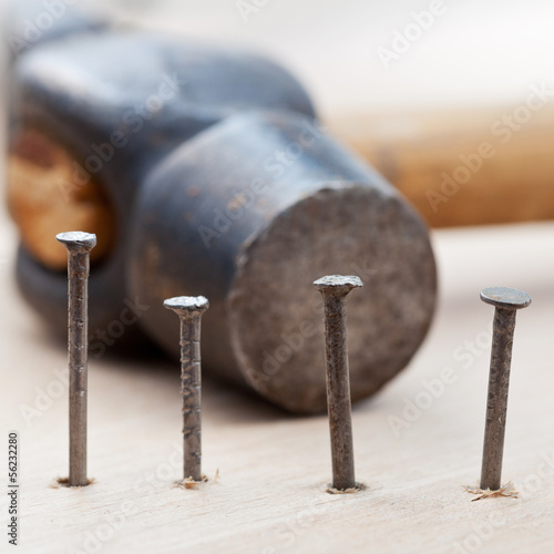 Photo: hammer and nails into wooden plank hammer and nails into wooden plank