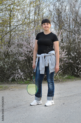 Photo: Woman standing with a badminton racket Woman standing with a badminton racket