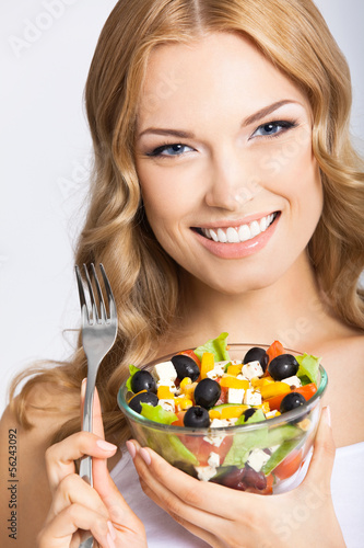 Photo: Woman with vegetarian salad, over gray Woman with vegetarian salad, over gray