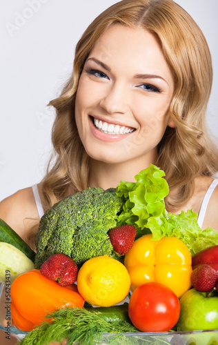 Photo: Young woman with vegetarian food, over gray Young woman with vegetarian food, over gray
