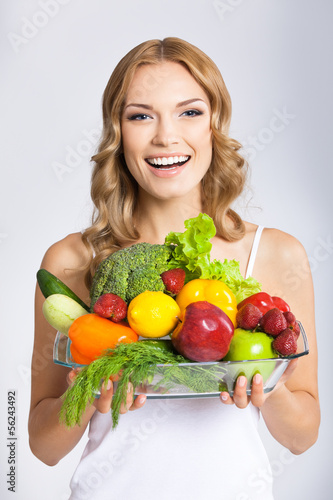 Photo: Young woman with vegetarian food, over gray Young woman with vegetarian food, over gray