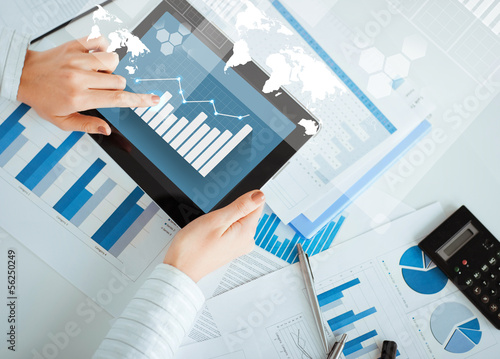 Photo: woman with tablet pc and chart papers woman with tablet pc and chart papers