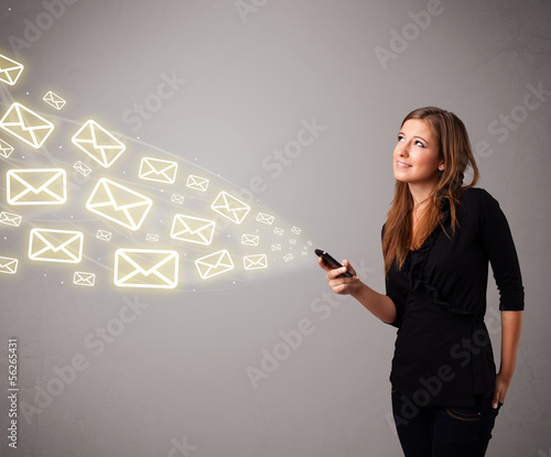 Photo: attractive young lady holding a phone with message icons attractive young lady holding a phone with message icons