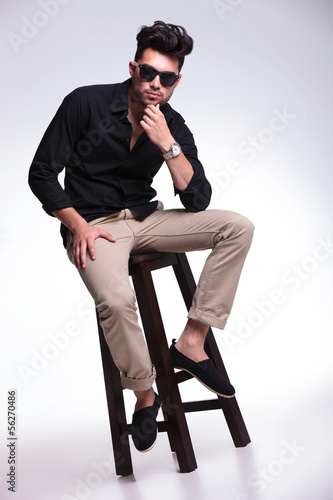 Photo: seated young man looks pensive seated young man looks pensive