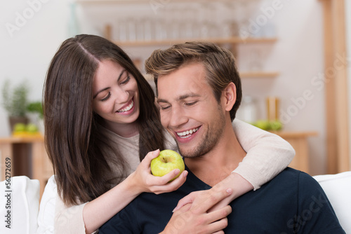 Photo: mädchen hält ihrem freund einen apfel vor die nase mädchen hält ihrem freund einen apfel vor die nase