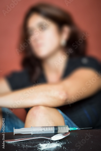 Photo: Syringe, drugs and depressed female drug addict Syringe, drugs and depressed female drug addict