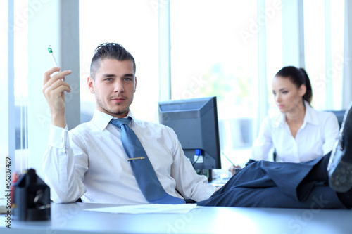 Photo: Happy businessman sitting in office Happy businessman sitting in office