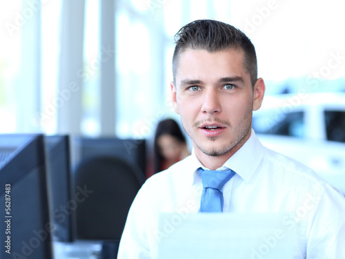 Photo: Happy businessman sitting in office Happy businessman sitting in office