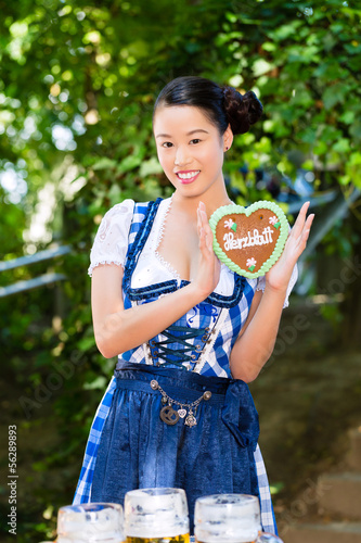 Photo: Asian Woman with Bavarian gingerbread heart Asian Woman with Bavarian gingerbread heart