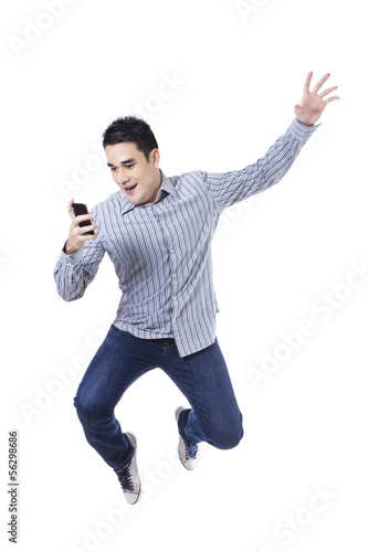 Photo: Young man jumping with a mobile phone Young man jumping with a mobile phone