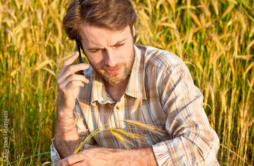 Photo: Farmer control wheat field while talking on mobile phone Farmer control wheat field while talking on mobile phone