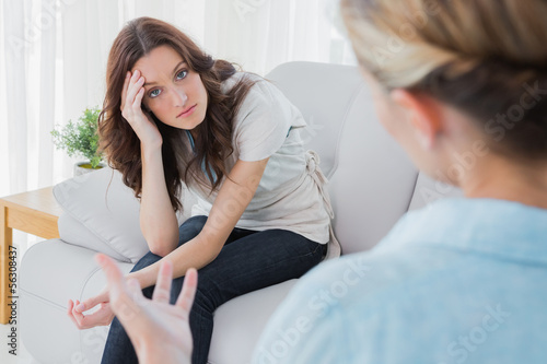 Photo: Worried woman sitting and looking at camera during therapy Worried woman sitting and looking at camera during therapy