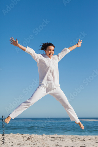 Photo: Happy woman jumping on the beach Happy woman jumping on the beach