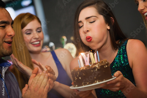 Photo: Attractive woman blowing the candles on her birthday cake Attractive woman blowing the candles on her birthday cake