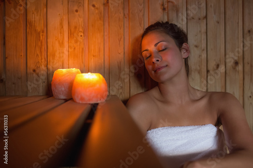 Photo: Happy brunette woman sitting in a sauna Happy brunette woman sitting in a sauna