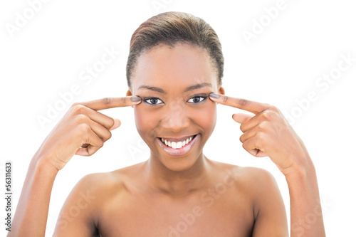 Photo: Smiling beautiful model pointing at her eyes Smiling beautiful model pointing at her eyes