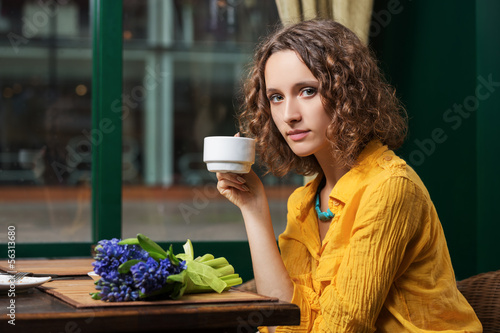 Photo: Sad young woman drinking tea at restaurant Sad young woman drinking tea at restaurant