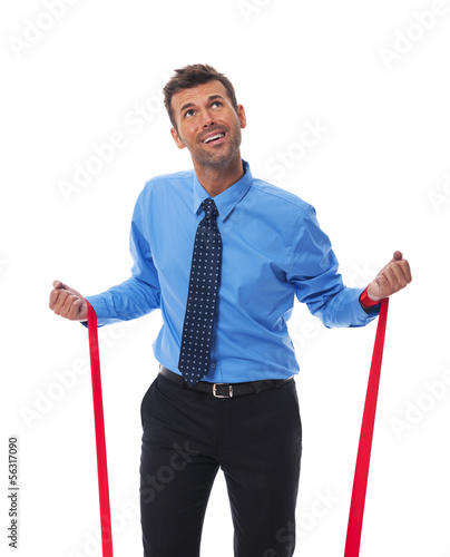 Photo: Business man trying free themselves from clutches of corporate Business man trying free themselves from clutches of corporate