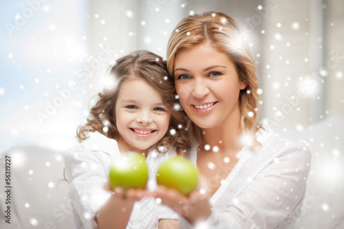 Photo: mother and daughter holding green apples mother and daughter holding green apples