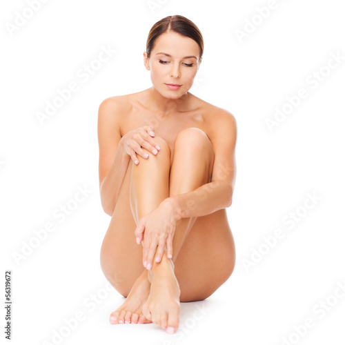 Photo: beautiful naked woman touching her legs beautiful naked woman touching her legs
