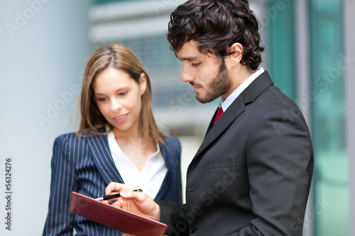 Photo: Businesspeople looking the agenda Businesspeople looking the agenda