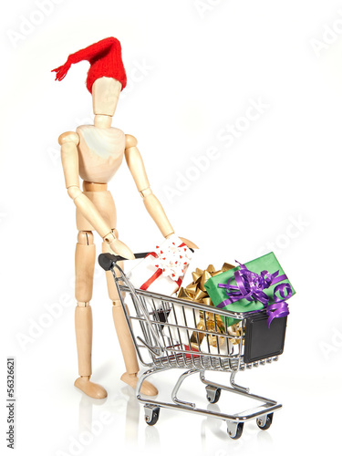 Photo: Wooden character with shopping cart and Christmas gifts Wooden character with shopping cart and Christmas gifts