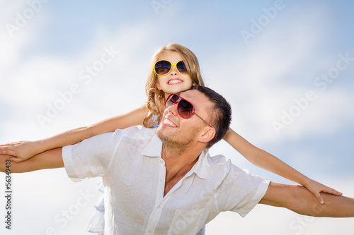 Photo: happy father and child in sunglasses over blue sky happy father and child in sunglasses over blue sky