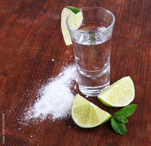 Photo: Tequila in glass on wooden table close-up Tequila in glass on wooden table close-up