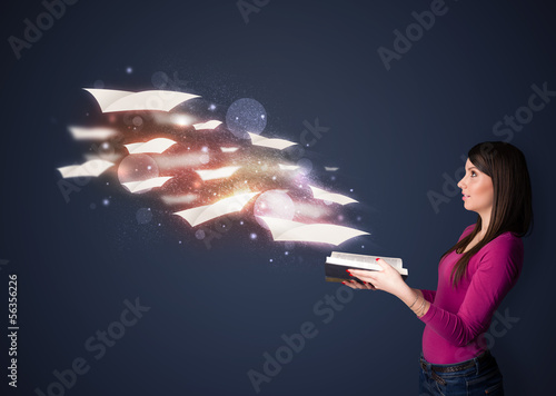 Photo: Young lady reading a book with flying sheets coming out of the b Young lady reading a book with flying sheets coming out of the b