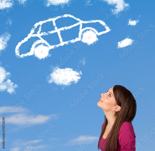 Photo: Young girl looking at car cloud on a blue sky Young girl looking at car cloud on a blue sky