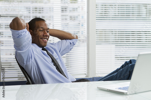 Photo: African-American business man taking a break at desk, horizontal African-American business man taking a break at desk, horizontal
