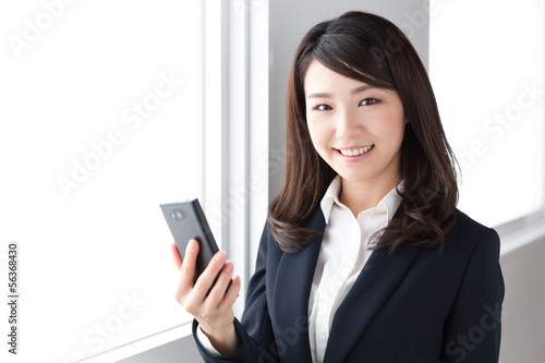 Photo: スマートフォンを見る女性 ビジネス スマートフォンを見る女性 ビジネス