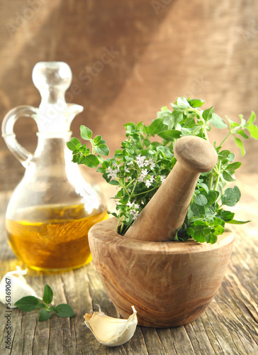 Photo: Oregano herb in wooden mortar and pestle. Oregano herb in wooden mortar and pestle.