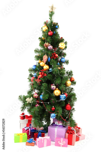 Photo: Decorated Christmas tree with gifts isolated on white Decorated Christmas tree with gifts isolated on white