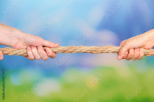 Photo: Tug of war, on bright background Tug of war, on bright background